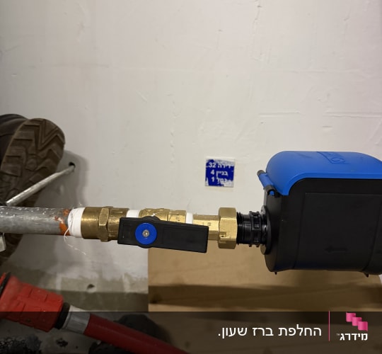 צנרת עם ברזים וכלים כחולים על קיר לבן